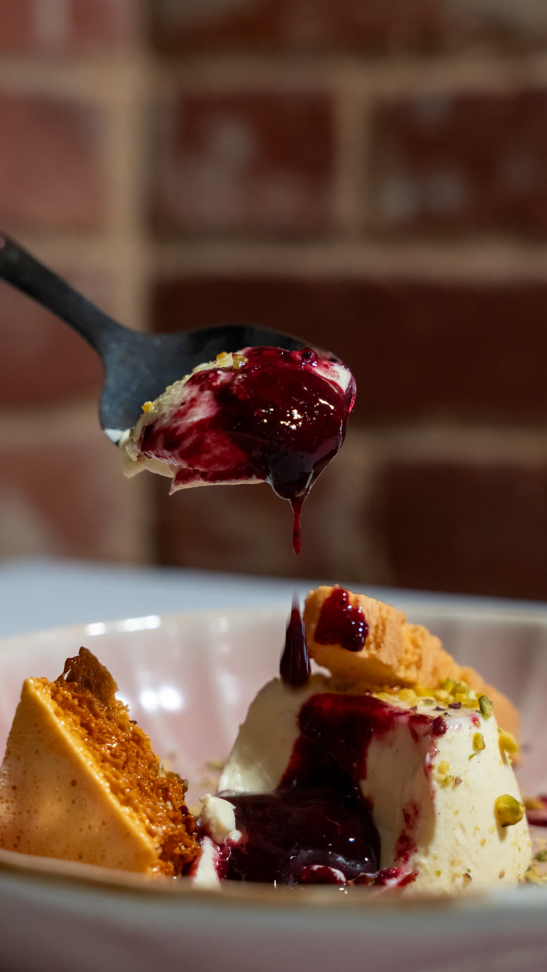 A pistachio panna cotta dessert with honeycomb and berry compote at The Lookout Barossa.