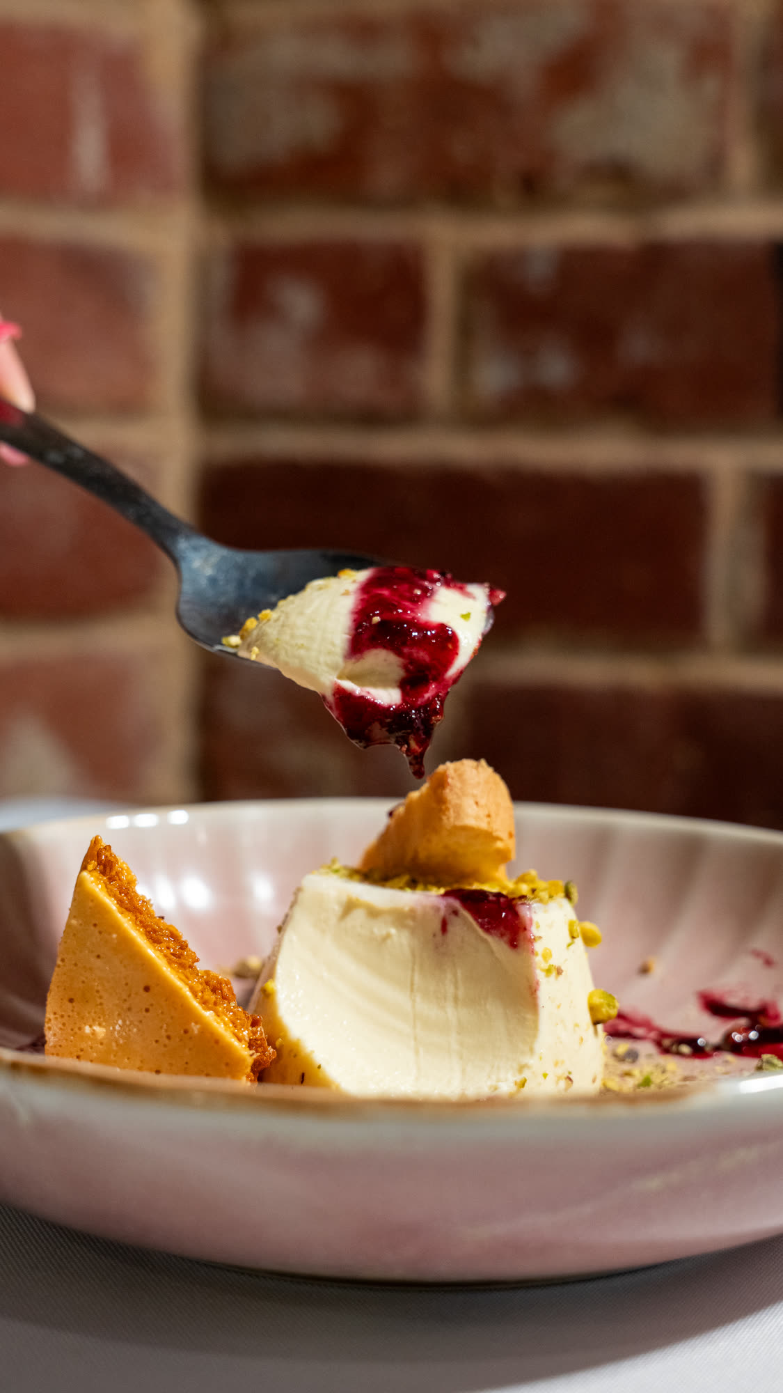 A pistachio panna cotta dessert with honeycomb and berry compote at The Lookout Barossa.