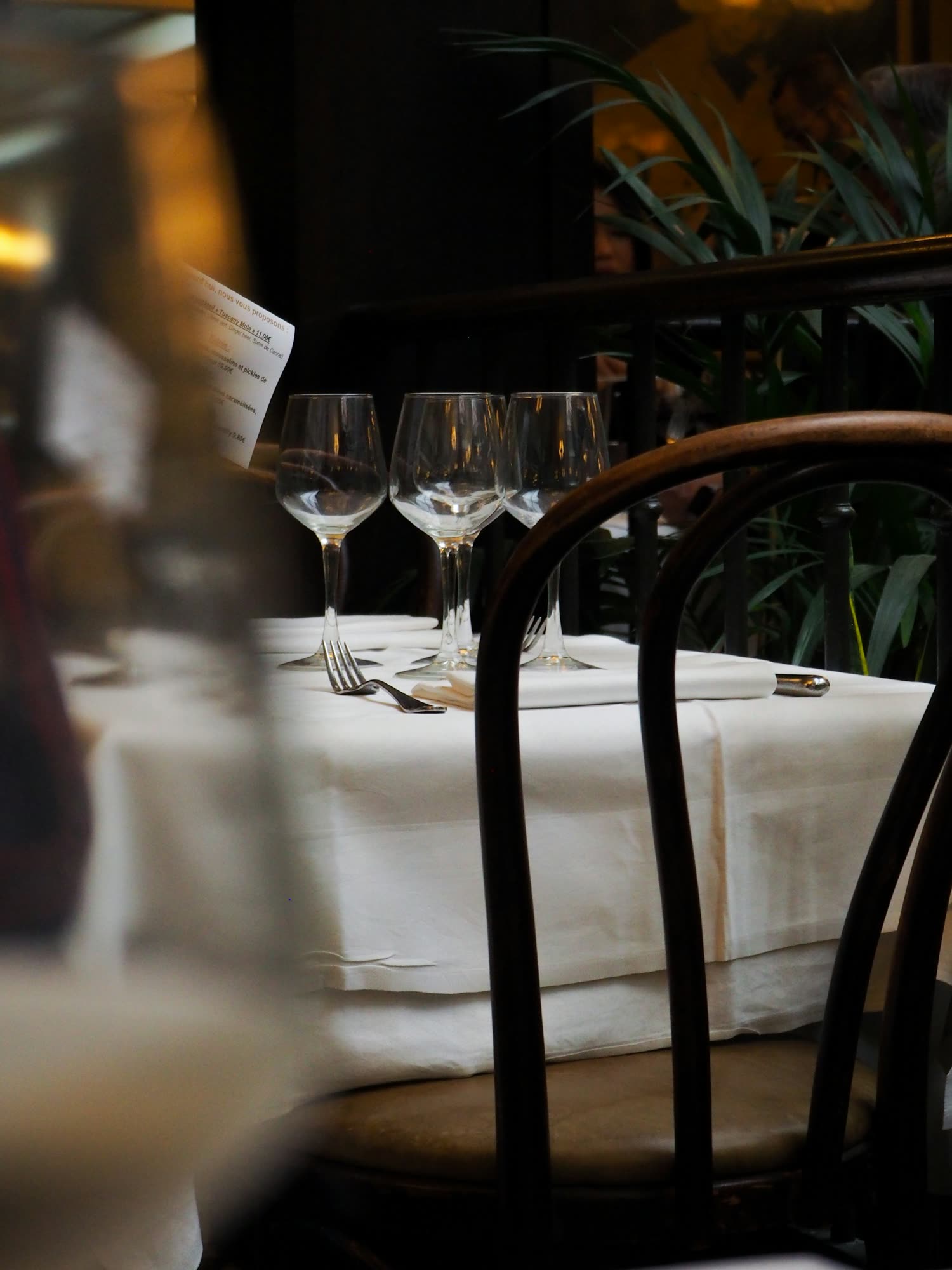 A white-linen table set with wine glasses beside a bentwood chair, generic stock photo pending real venue photography.